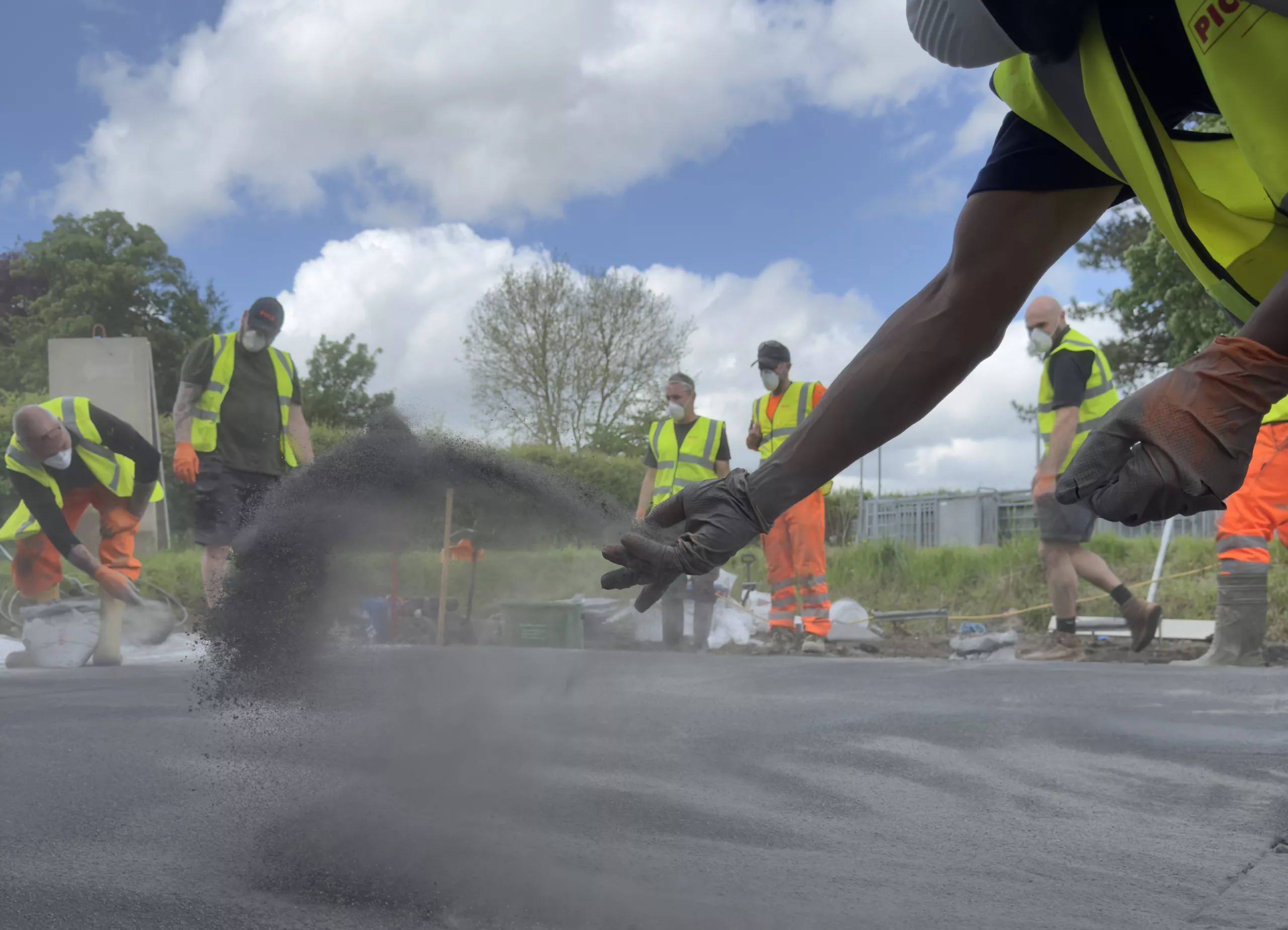 PICS team applying pattern imprinted concrete outdoors in high-vis gear.