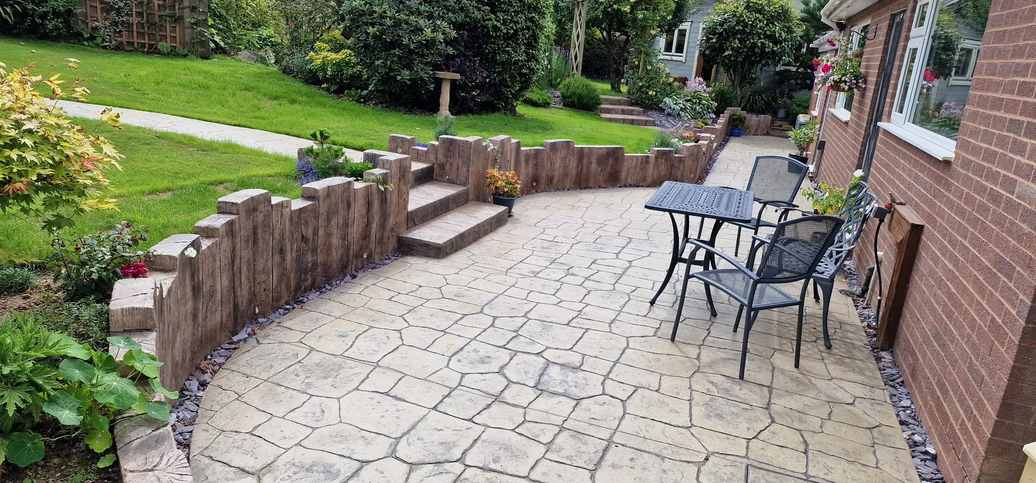 PICS pattern imprinted concrete patio with retaining wall and garden furniture.